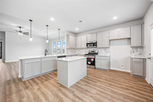 520 Barton Place Dr, Cleveland, TX 77327 - kitchen featuring stainless steel appliances, a sink, a peninsula, backsplash, and a kitchen island