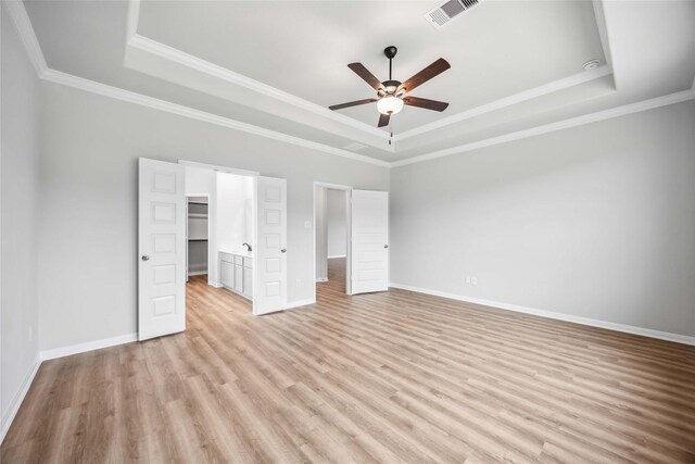 520 Barton Place Dr, Cleveland, TX 77327 - unfurnished bedroom with a raised ceiling, light wood-type flooring, crown molding, baseboards, and a spacious closet