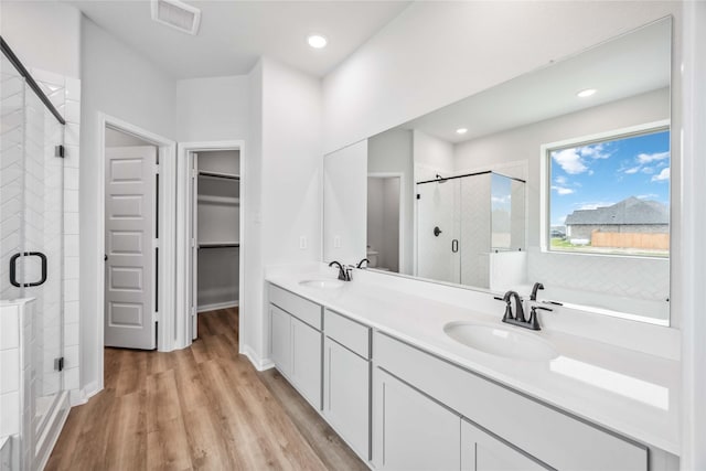 520 Barton Place Dr, Cleveland, TX 77327 - full bathroom with a stall shower, a spacious closet, double vanity, wood finished floors, and recessed lighting