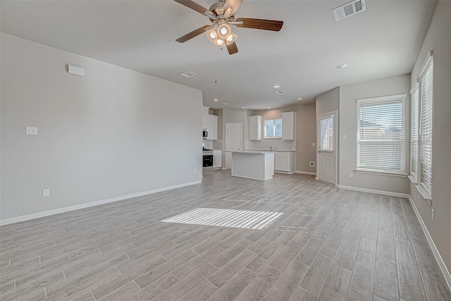 210 Emerald Thicket Ln, Huffman, TX 77336 - unfurnished living room with light wood finished floors, a ceiling fan, baseboards, and recessed lighting