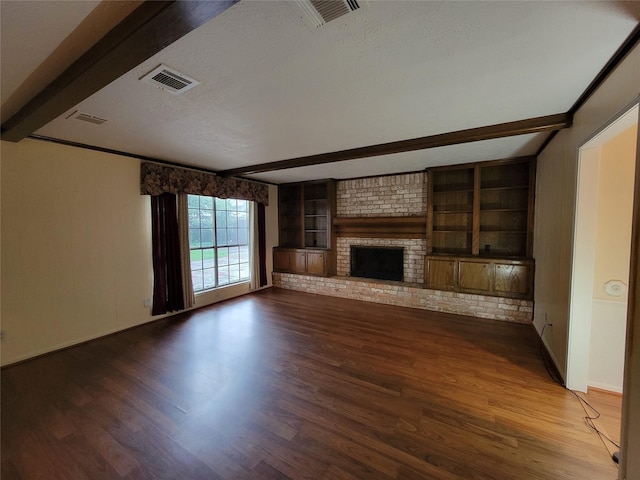 5211 Alamosa Ln, Spring, TX 77379 - unfurnished living room featuring beam ceiling, wood finished floors, a textured ceiling, a brick fireplace, and built in features
