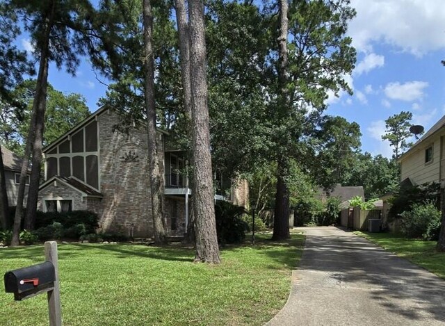 5211 Alamosa Ln, Spring, TX 77379 - view of front of house featuring brick siding, a front yard, and driveway