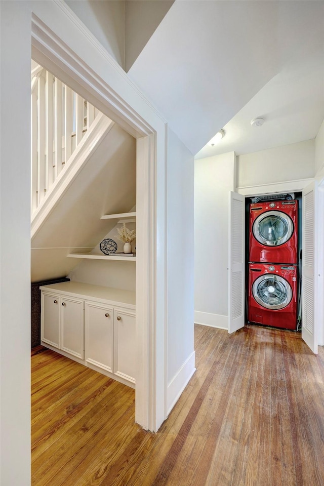 1639 Hawthorne St, Houston, TX 77006 - hall featuring stacked washer / dryer, light wood-style floors, baseboards, and lofted ceiling