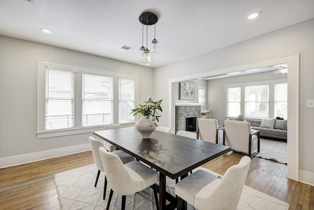 1639 Hawthorne St, Houston, TX 77006 - dining area with baseboards, a fireplace, wood-type flooring, and recessed lighting
