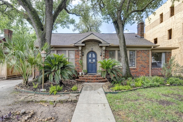 1639 Hawthorne St, Houston, TX 77006 - tudor house with brick siding, a chimney, and roof with shingles