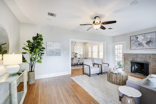 1639 Hawthorne St, Houston, TX 77006 - living room featuring a brick fireplace, wood finished floors, baseboards, and ceiling fan