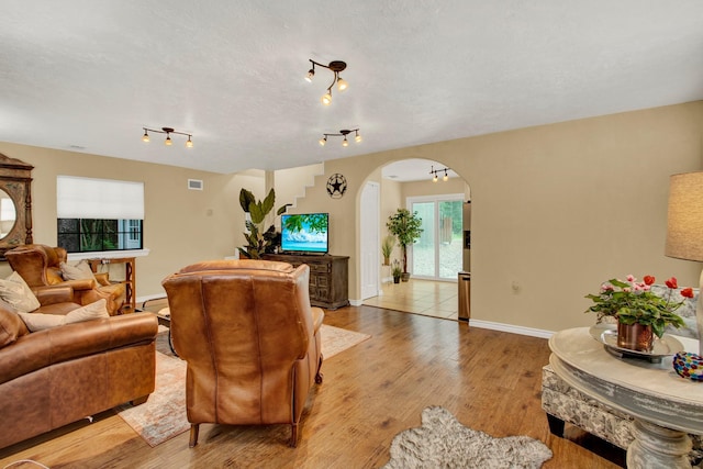 22827 Edward Ln, Tomball, TX 77377 - living room featuring arched walkways and light wood-style floors