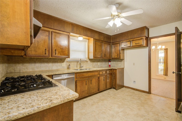 55 Flag Ct, Lake Jackson, TX 77566 - kitchen featuring a sink, appliances with stainless steel finishes, brown cabinets, decorative backsplash, and a textured ceiling