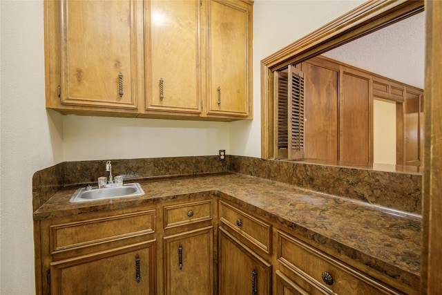 55 Flag Ct, Lake Jackson, TX 77566 - kitchen with a sink, dark countertops, and brown cabinetry