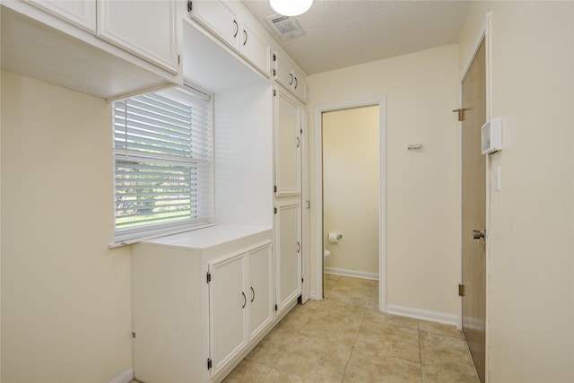 55 Flag Ct, Lake Jackson, TX 77566 - corridor featuring baseboards, a textured ceiling, and light tile patterned floors