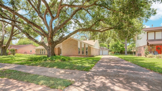 55 Flag Ct, Lake Jackson, TX 77566 - mid-century inspired home featuring brick siding, a front lawn, central AC unit, and a detached garage