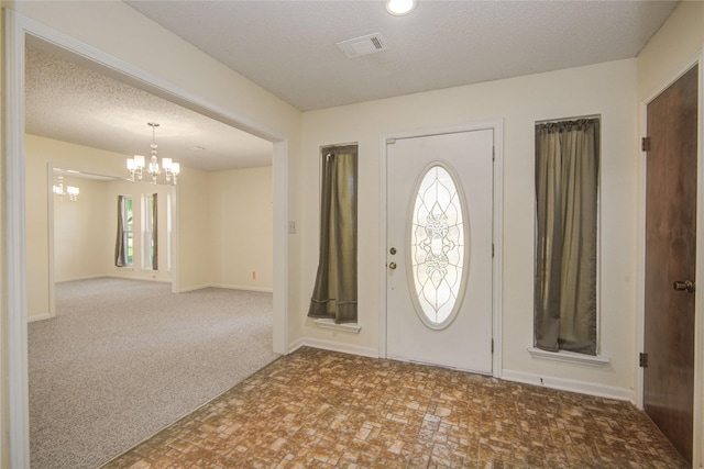 55 Flag Ct, Lake Jackson, TX 77566 - carpeted entryway with a chandelier and a textured ceiling