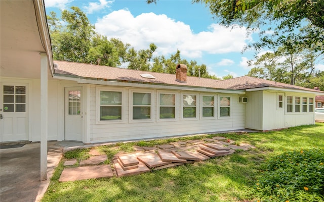 55 Flag Ct, Lake Jackson, TX 77566 - rear view of house featuring a chimney, a yard, and an AC wall unit