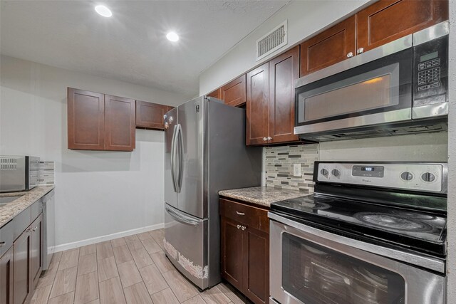 10534 Towne Square Rd, Sugar Land, TX 77498 - kitchen with appliances with stainless steel finishes, tasteful backsplash, baseboards, light stone countertops, and recessed lighting