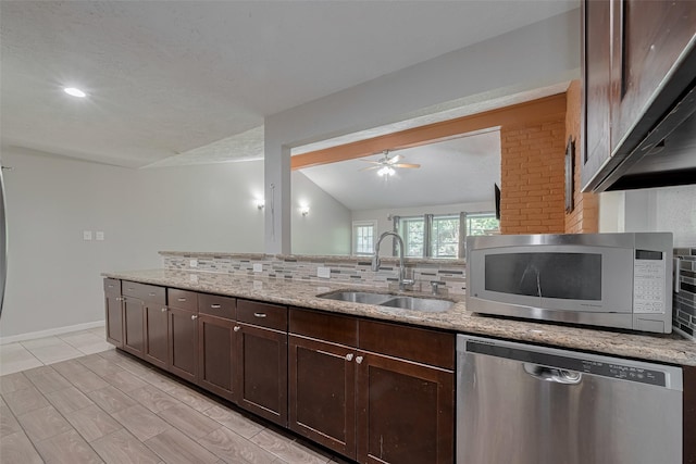 10534 Towne Square Rd, Sugar Land, TX 77498 - kitchen featuring appliances with stainless steel finishes, a sink, backsplash, dark brown cabinets, and light stone countertops