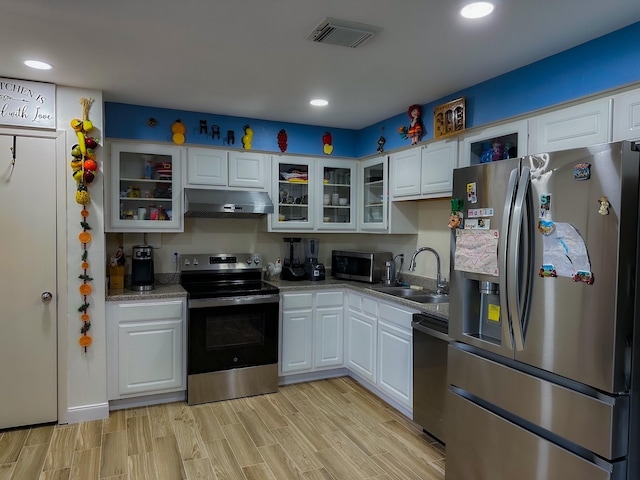 3426 Wuthering Heights Dr, Houston, TX 77045 - kitchen featuring stainless steel appliances, a sink, under cabinet range hood, white cabinetry, and recessed lighting