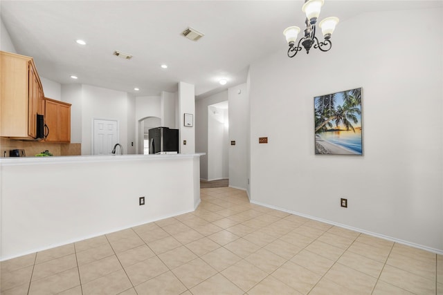 18206 Eton Ridge Ct, Richmond, TX 77407 - kitchen featuring freestanding refrigerator, black microwave, a peninsula, a chandelier, and recessed lighting