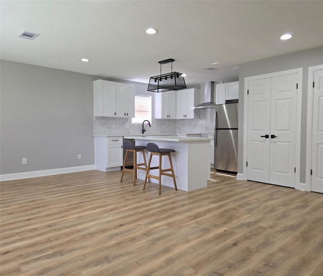 6502 Trail Valley Way, Houston, TX 77086 - kitchen with freestanding refrigerator, white cabinets, light countertops, light wood-style flooring, and backsplash