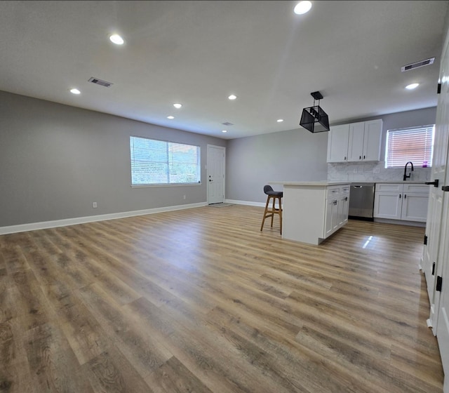 6502 Trail Valley Way, Houston, TX 77086 - kitchen featuring dishwasher, a breakfast bar area, recessed lighting, open floor plan, and white cabinetry