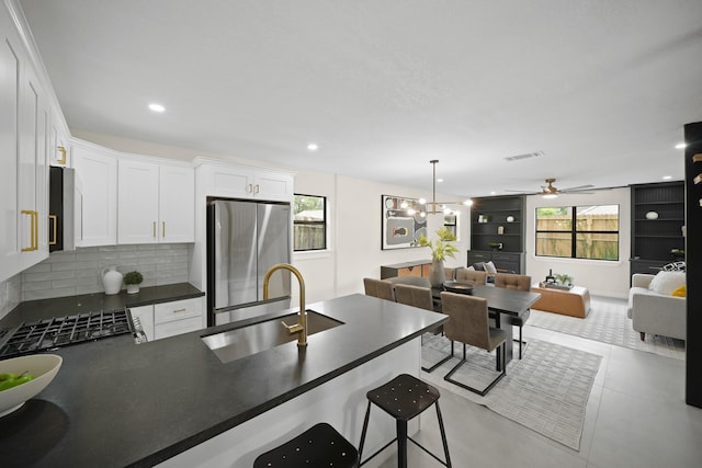 4813 Hummingbird St, Houston, TX 77035 - kitchen with stainless steel fridge, dark countertops, a peninsula, backsplash, and white cabinets