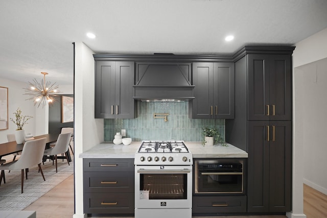 4813 Hummingbird St, Houston, TX 77035 - kitchen with white range with gas cooktop, custom exhaust hood, a chandelier, oven, and decorative backsplash
