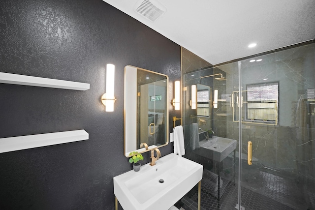 4813 Hummingbird St, Houston, TX 77035 - bathroom with a marble finish shower, a textured wall, and recessed lighting