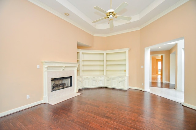 14403 Reissen Ln, Houston, TX 77069 - unfurnished living room with a ceiling fan, dark wood-type flooring, a premium fireplace, a high ceiling, and baseboards