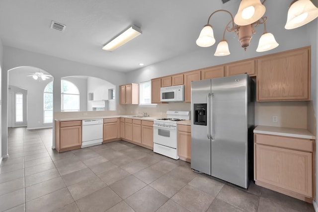 25819 Oakridge Forest Ln, Spring, TX 77386 - kitchen with white appliances, light brown cabinets, a sink, and arched walkways