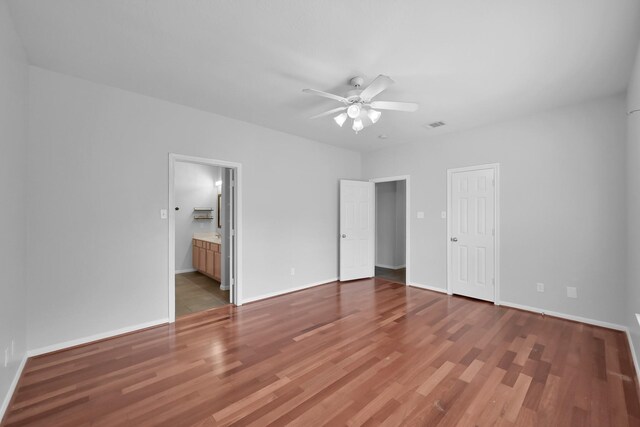 25819 Oakridge Forest Ln, Spring, TX 77386 - unfurnished bedroom featuring wood finished floors, baseboards, and connected bathroom