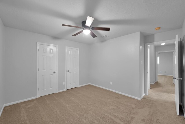 25819 Oakridge Forest Ln, Spring, TX 77386 - unfurnished bedroom featuring light carpet, baseboards, multiple closets, and ceiling fan