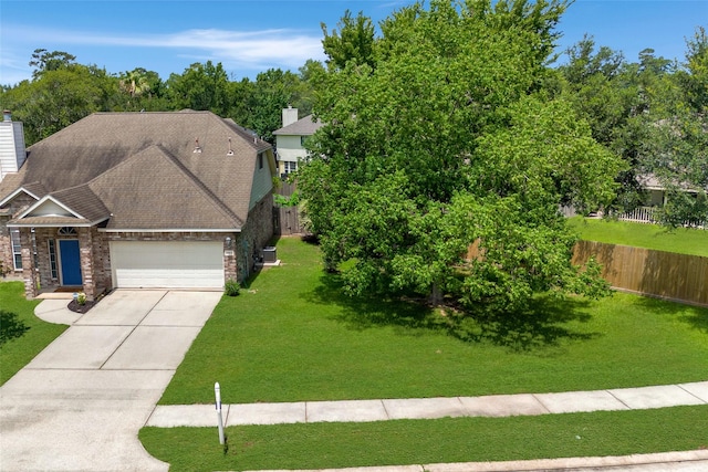 25819 Oakridge Forest Ln, Spring, TX 77386 - view of front of house with stone siding, a garage, a chimney, and concrete driveway
