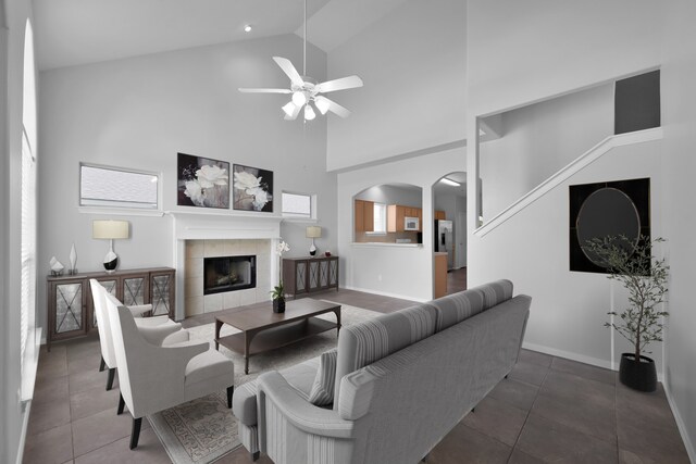 25819 Oakridge Forest Ln, Spring, TX 77386 - living room featuring a ceiling fan, arched walkways, high vaulted ceiling, a fireplace, and tile patterned floors