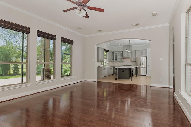 70 N Knights Crossing Dr, The Woodlands, TX 77382 - unfurnished living room featuring a ceiling fan, light wood-style flooring, baseboards, arched walkways, and ornamental molding
