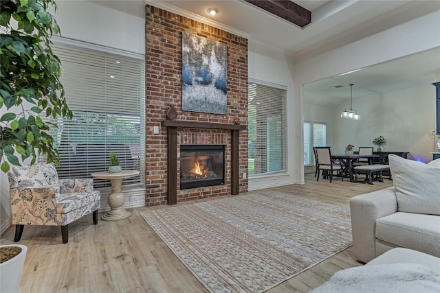 11 Hillsborough Dr E, Montgomery, TX 77356 - living area with wood finished floors, a fireplace, a chandelier, ornamental molding, and a high ceiling