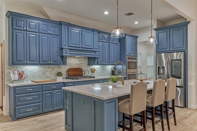 11 Hillsborough Dr E, Montgomery, TX 77356 - kitchen featuring blue cabinets, stainless steel appliances, light wood finished floors, light countertops, and recessed lighting