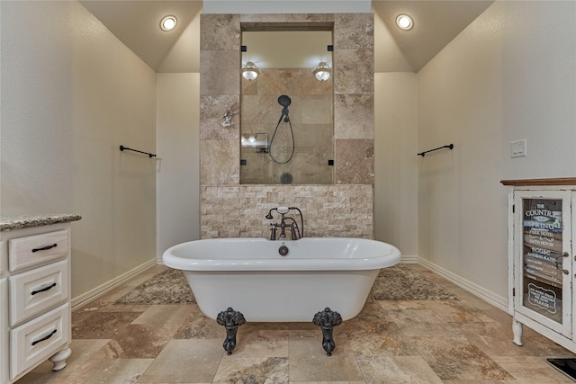 11 Hillsborough Dr E, Montgomery, TX 77356 - full bathroom featuring stone tile flooring, a freestanding bath, baseboards, and walk in shower