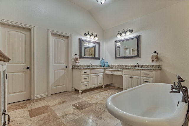 11 Hillsborough Dr E, Montgomery, TX 77356 - full bathroom with double vanity, a soaking tub, lofted ceiling, stone tile flooring, and baseboards
