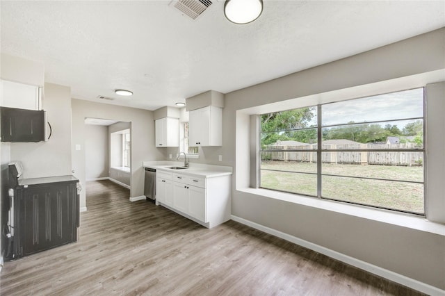 9627 Crooked Wood Ln, Houston, TX 77086 - kitchen featuring a sink, dishwasher, baseboards, and light countertops