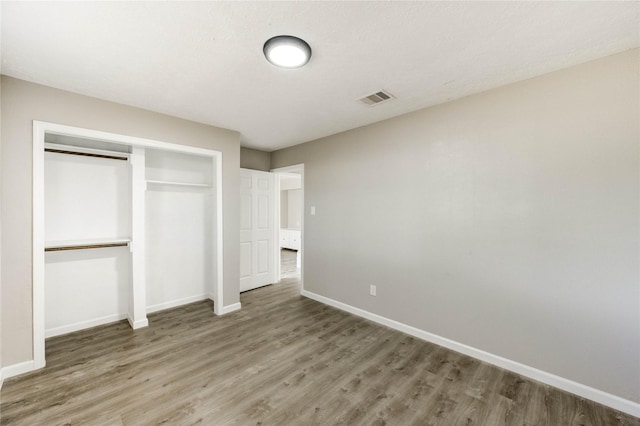 9627 Crooked Wood Ln, Houston, TX 77086 - unfurnished bedroom with wood finished floors, baseboards, and a closet