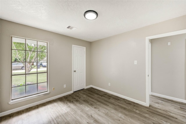 9627 Crooked Wood Ln, Houston, TX 77086 - spare room with wood finished floors, baseboards, and a textured ceiling