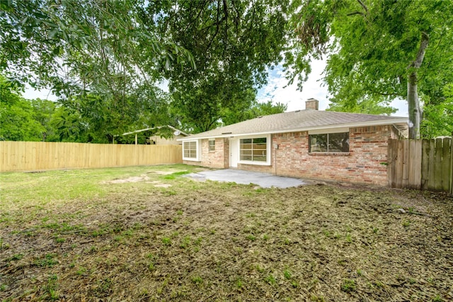 9627 Crooked Wood Ln, Houston, TX 77086 - back of property with a patio, brick siding, and a chimney