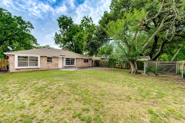 9627 Crooked Wood Ln, Houston, TX 77086 - rear view of house featuring a patio, brick siding, and a chimney