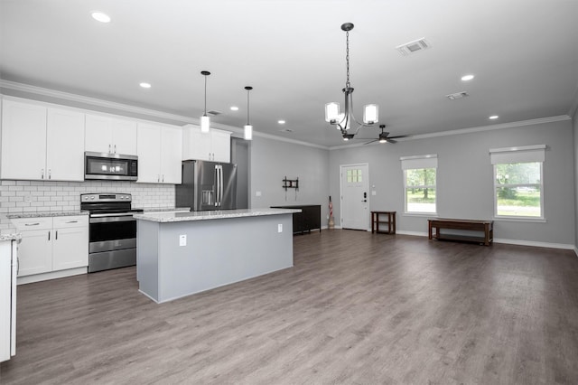 701 Sandy Brook Dr, Lufkin, TX 75901 - kitchen featuring appliances with stainless steel finishes, a center island, a chandelier, recessed lighting, and crown molding