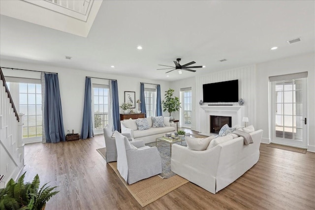 111 Poncho St, Anahuac, TX 77514 - living area with wood finished floors, stairway, a glass covered fireplace, a ceiling fan, and recessed lighting