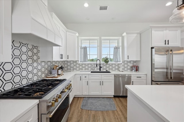 111 Poncho St, Anahuac, TX 77514 - kitchen with high quality appliances, a sink, light countertops, light wood-style flooring, and white cabinetry