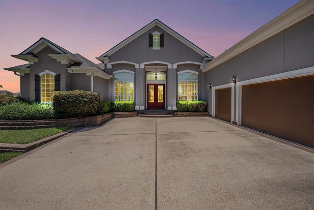 5925 Oak Leaf Ct, Conroe, TX 77304 - view of front of house featuring french doors, stucco siding, driveway, and a garage