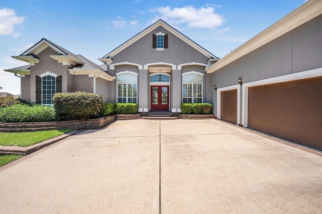 5925 Oak Leaf Ct, Conroe, TX 77304 - view of front of property featuring french doors, stucco siding, driveway, and an attached garage