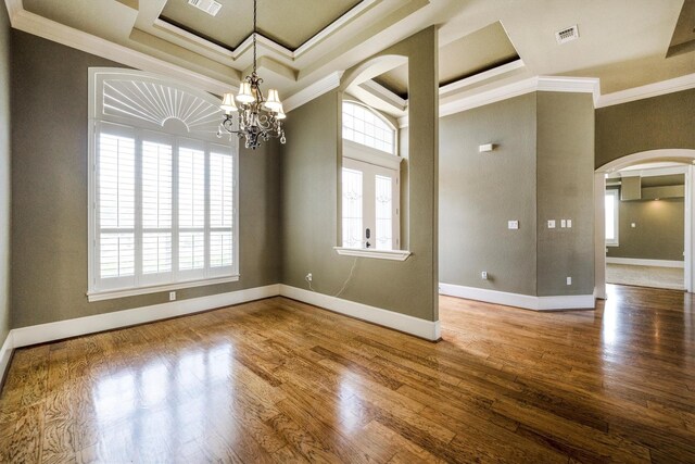 5925 Oak Leaf Ct, Conroe, TX 77304 - spare room featuring arched walkways, plenty of natural light, crown molding, a chandelier, and wood finished floors