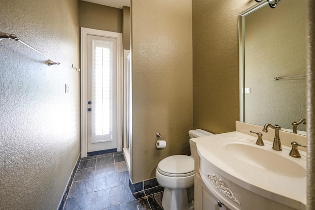 5925 Oak Leaf Ct, Conroe, TX 77304 - bathroom with an enclosed shower, toilet, vanity, baseboards, and a textured wall