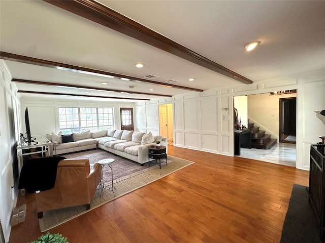 11219 Lorton Dr, Houston, TX 77070 - living area featuring a decorative wall, wood finished floors, beam ceiling, stairs, and recessed lighting